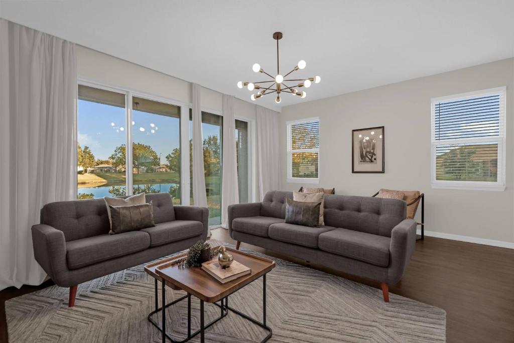 a living room with two couches and a table at Brand New Themed Home With Lake View 11 in Davenport