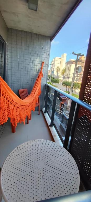 a balcony with a table and a hammock on a building at PARK DEL PRADO - Conforto pertinho do mar in Cabedelo
