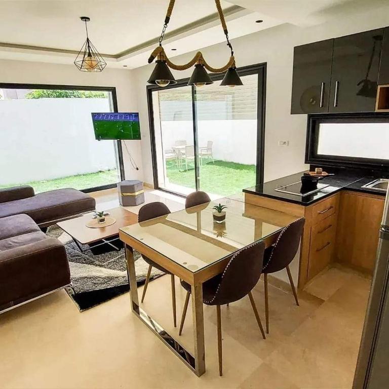 a living room with a table and a couch at Résidence petit paris RDC2 in Kelibia