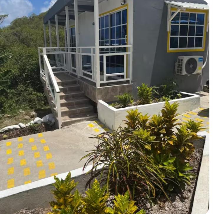 a house with stairs and plants in front of it at Posada MaiMai in Providencia
