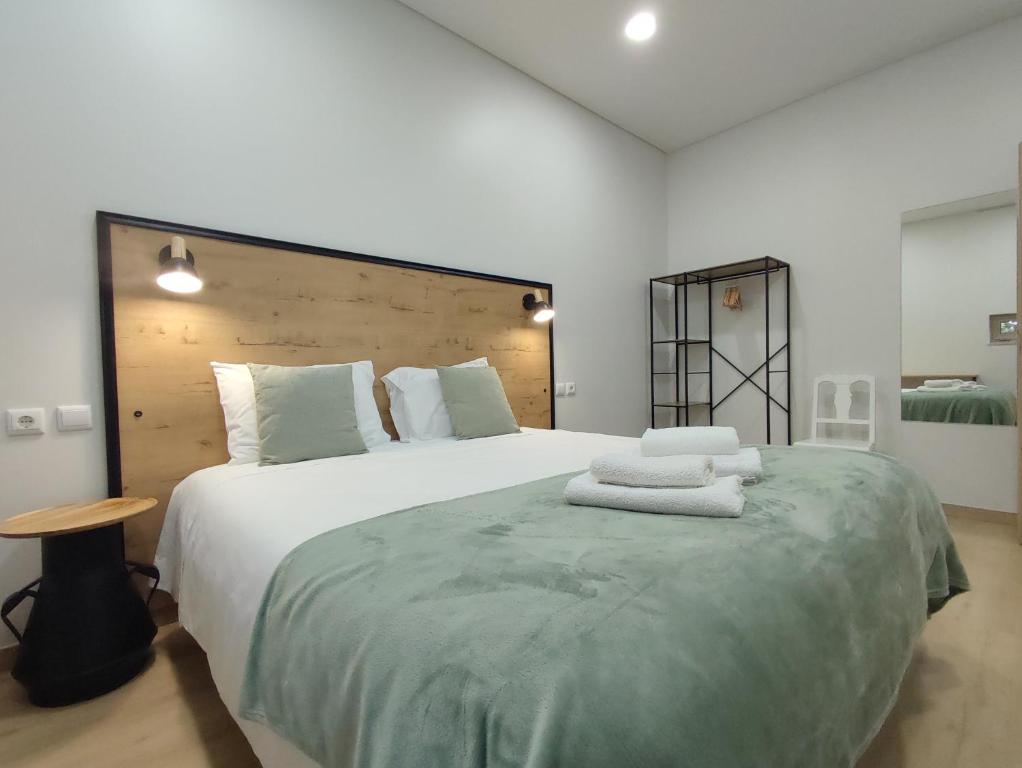 a bedroom with a large bed with towels on it at Barcelos Habadia Adega in Lijó