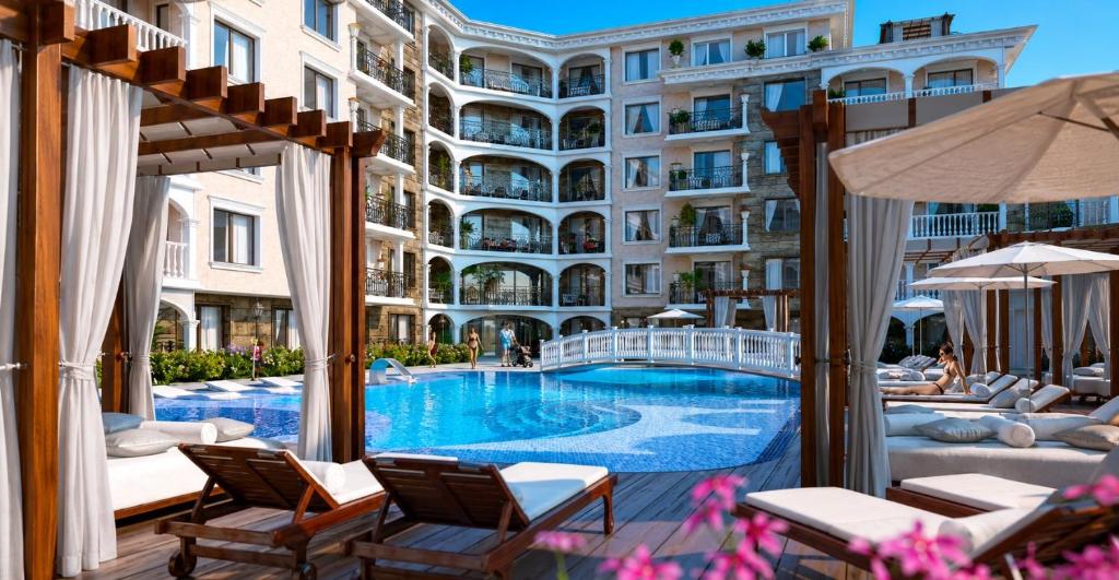 a hotel swimming pool with chairs and a building at Purple Rose Apartment Valencia Gardens in Nesebar