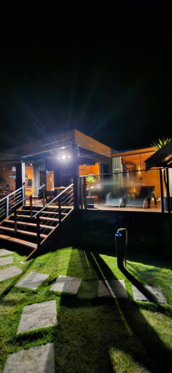a house at night with a bus in the distance at Chalé Container Lufre in Santo Antônio do Pinhal