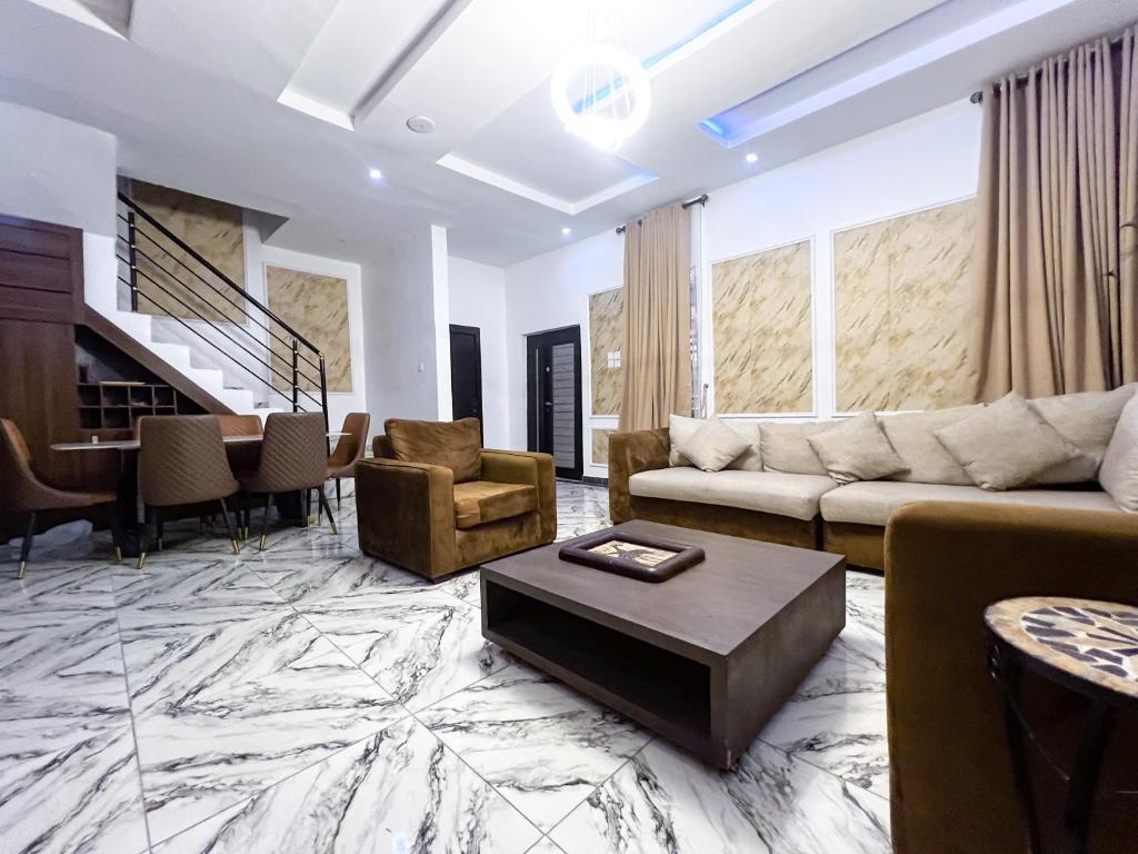 a living room with a couch and a table at Oak Atlantic Layout - OTITO Suites in Lekki