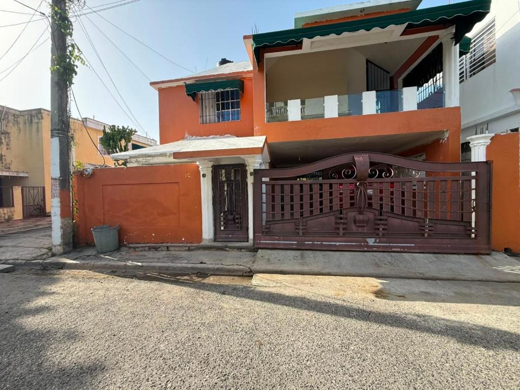 an orange house with a gate in front of it at Fantástico in Juan López