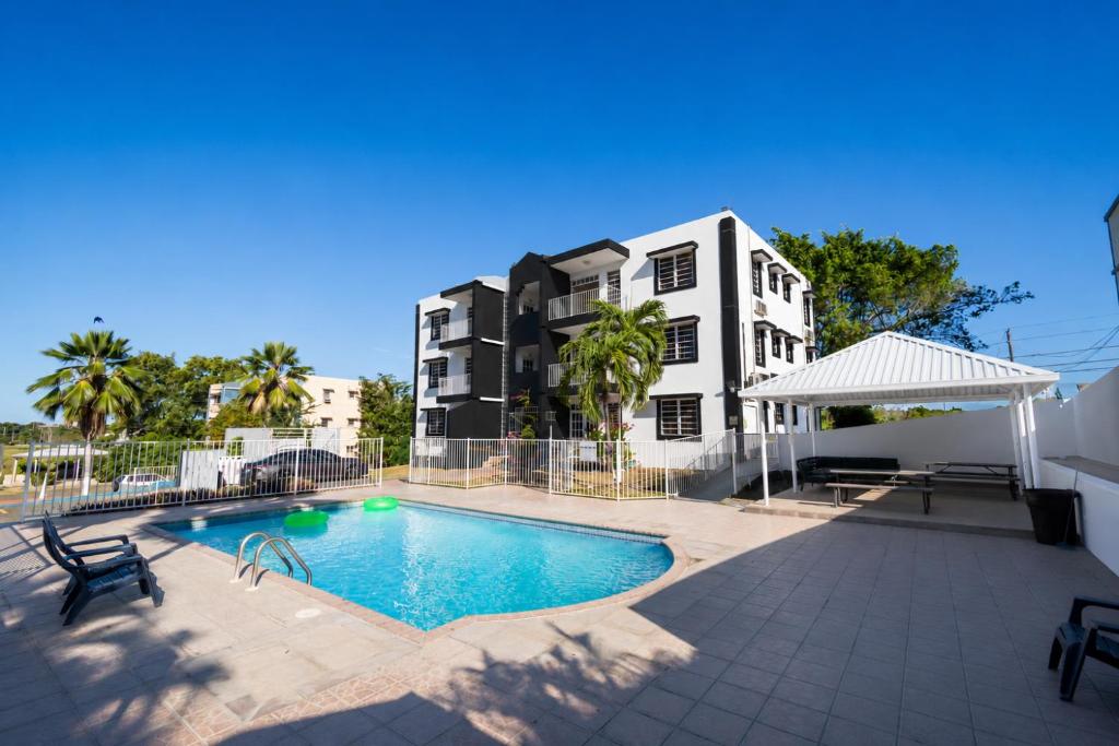 a swimming pool in front of a building at West Coast Apartments in Boqueron