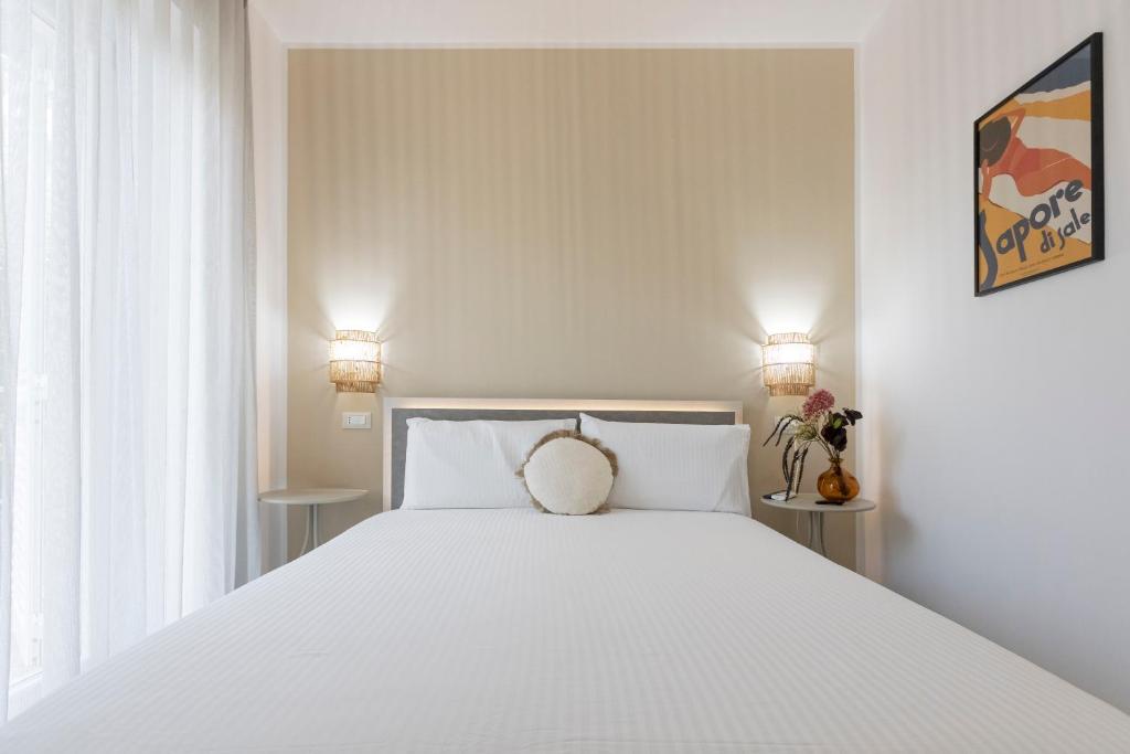 a bedroom with a large white bed with two lamps at Dimore Margherita in Petacciato