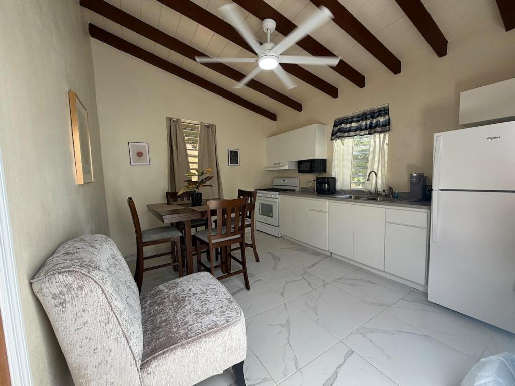 a kitchen with a table and chairs and a refrigerator at Villadeco Escape, Gated Cottage with Generator in West End