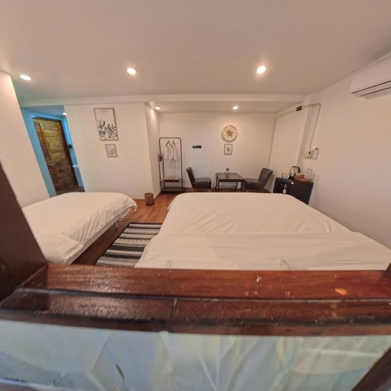 a bedroom with two beds and a desk in it at Mocha Latte Homestay & Cafe in Chiang Rai