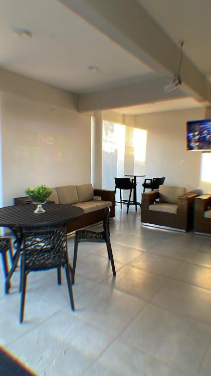 a living room with a table and a couch at Recanto Veraneio in Londrina