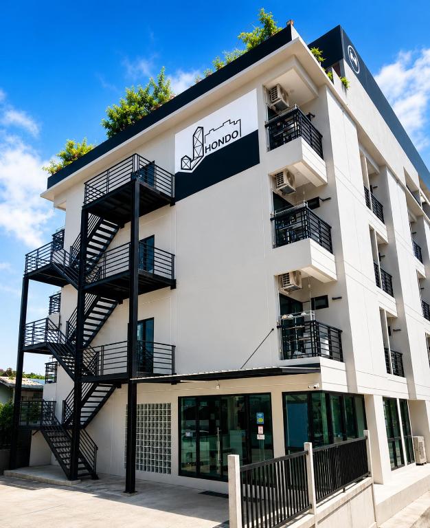 a white building with a black fire escape at เจฮอนโด อพาร์ตเมนต์ in Ban Si Than