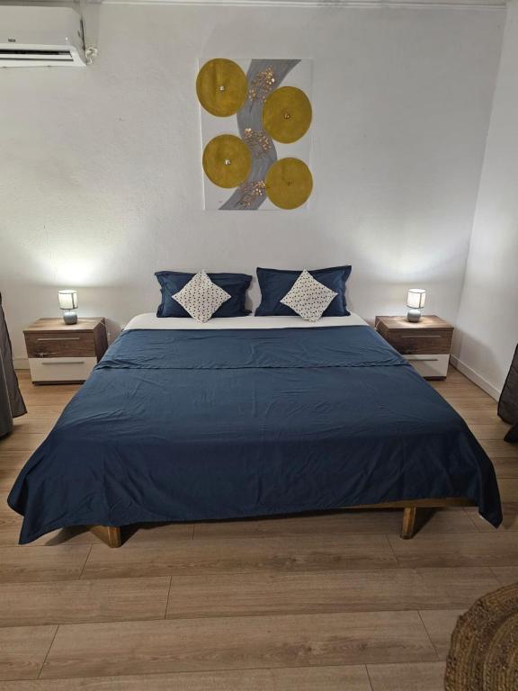 a bedroom with a blue bed with blue pillows at Paradies Caraïbes II in Les Abymes