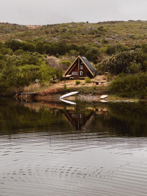 a house on the shore of a body of water at Waterfall Farm Self-Catering Cottages Citrusdal in Citrusdal
