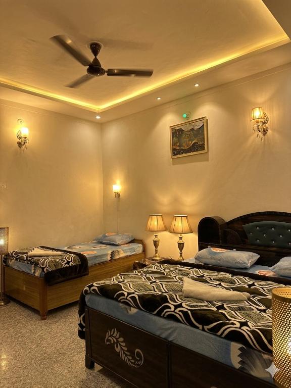 a bedroom with two beds and a ceiling fan at The quiet corner homestay in Rudraprayāg