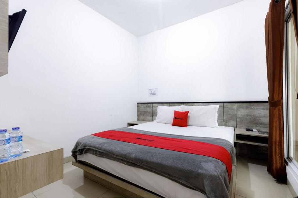 a bedroom with a bed with a red pillow at RedDoorz Premium @ Ampera Raya 2 in Jakarta
