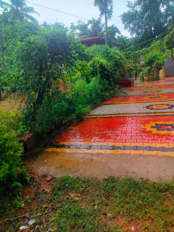 a fallen tree on a red and yellow sidewalk at Manjunatha nilaya sute delux ordinary room in Kollūru