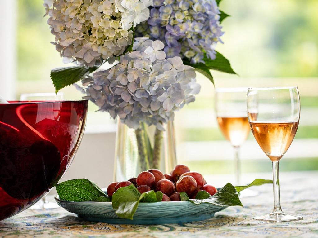a table with two glasses of wine and a bowl of fruit at Knot in Shodoshima