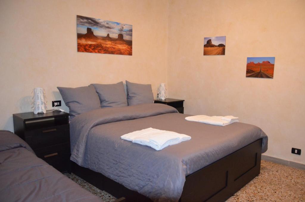 una camera da letto con due letti con asciugamani sopra di Bed&Breakfast Villa Bellini a Catania