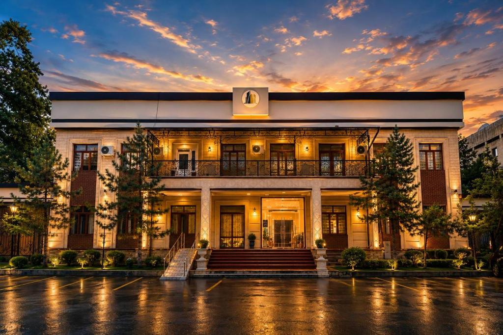 a large white building with a staircase in front of it at Amor fati hotel Tashkent in Katartal