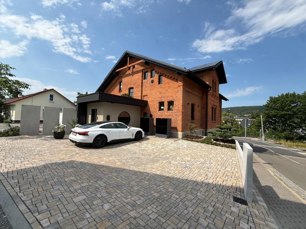 a white car parked in front of a brick building at Gleisbett 12-1 in Meiningen
