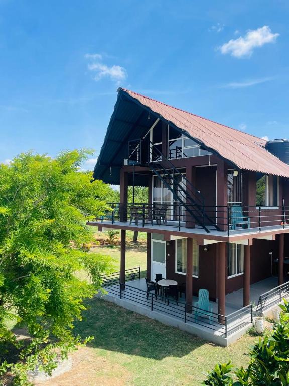 a house with a red roof and a tree at Relax Cottage in Mailagamuwa