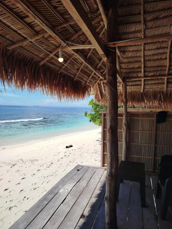 a view of the beach from a straw hut at KAINORA Guest Hause in Pulau Batanta