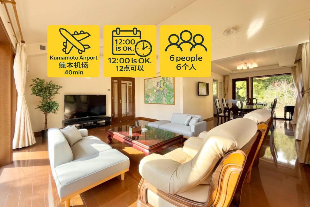 ein Wohnzimmer mit weißen Möbeln und gelben Schildern in der Unterkunft FUWARI-kumamoto-12時チェックアウトでゆったり滞在 パターゴルフと絶景を楽しむ1日1組宿 in Aso