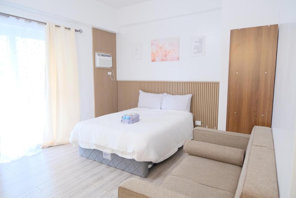 a hotel room with a bed and a couch at Airport Gem with Pool and Gym in Pusok