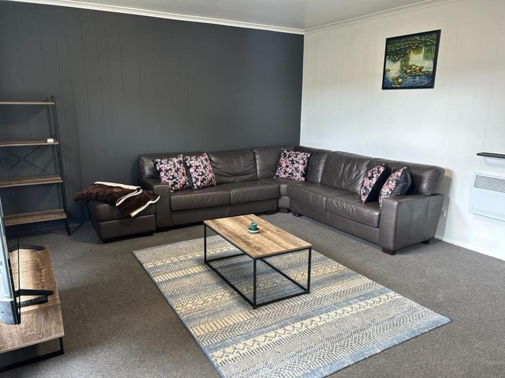 a living room with a leather couch and a coffee table at Comara Jindabyne Unit 2 in Jindabyne