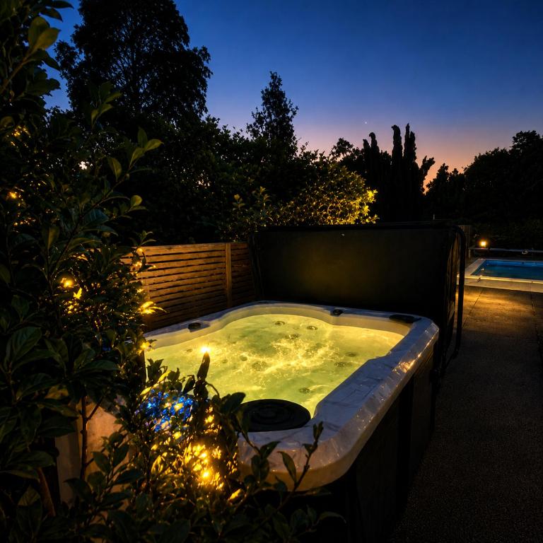 a jacuzzi tub in a backyard at night at Kitchen Garden Studio Spa - Bed and Breakfast in Auckland