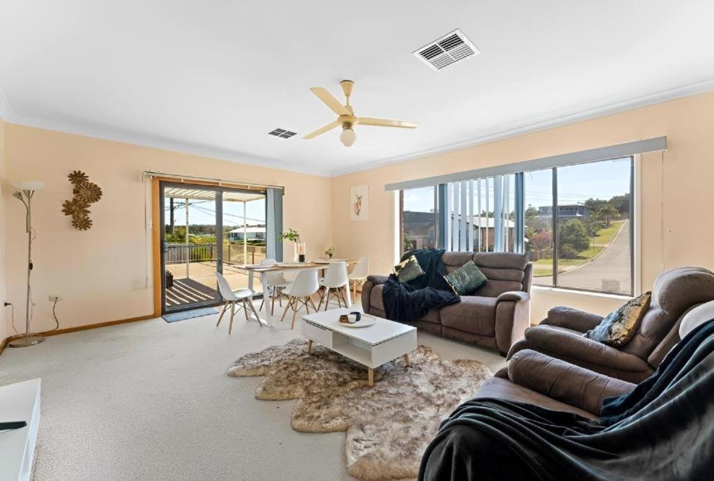 a living room with a couch and a table at Cheerful Beach house at Redhead - BBQ, Beach, Views in Redhead