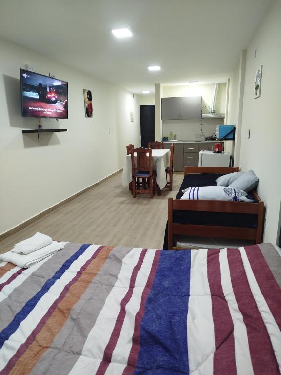 a room with two beds and a flat screen tv at Departamento bonito con balcón in La Banda
