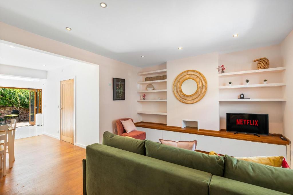 a living room with a green couch and a television at Leafy Haven By My Getaways in Brighton & Hove