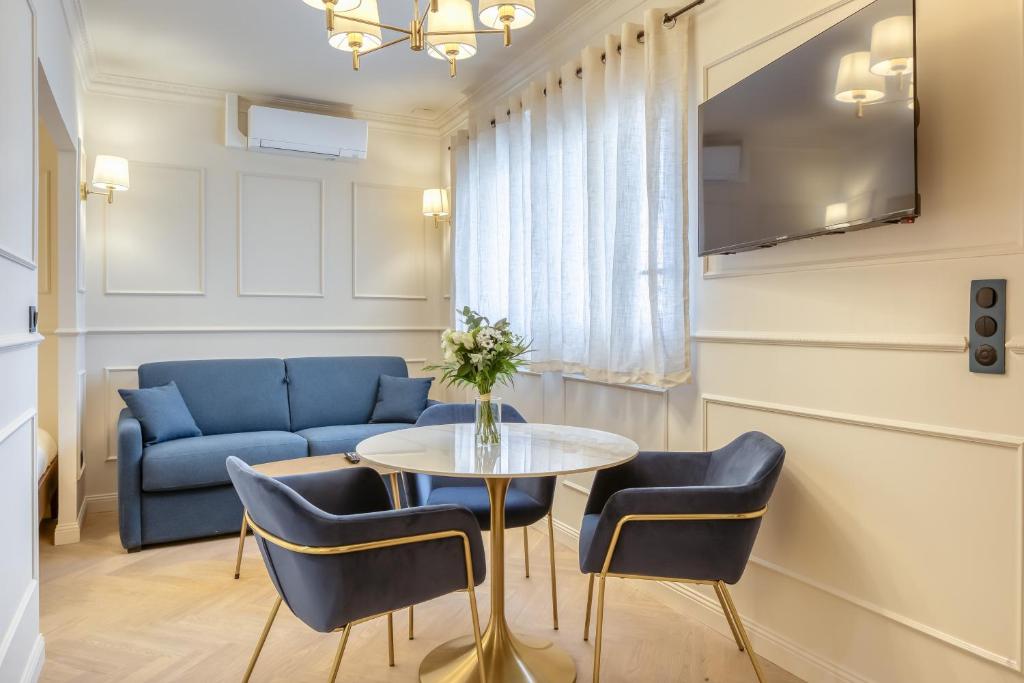 a living room with a table and chairs and a couch at Studios - Appartements Le Médicis in Rouen