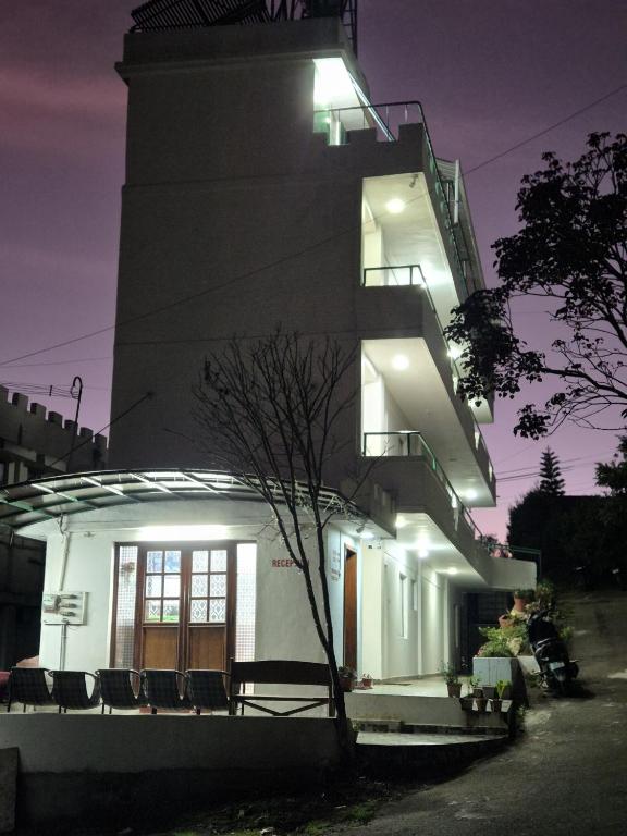a building with a tower with a staircase next to it at Shabeer's White Castle in Ooty