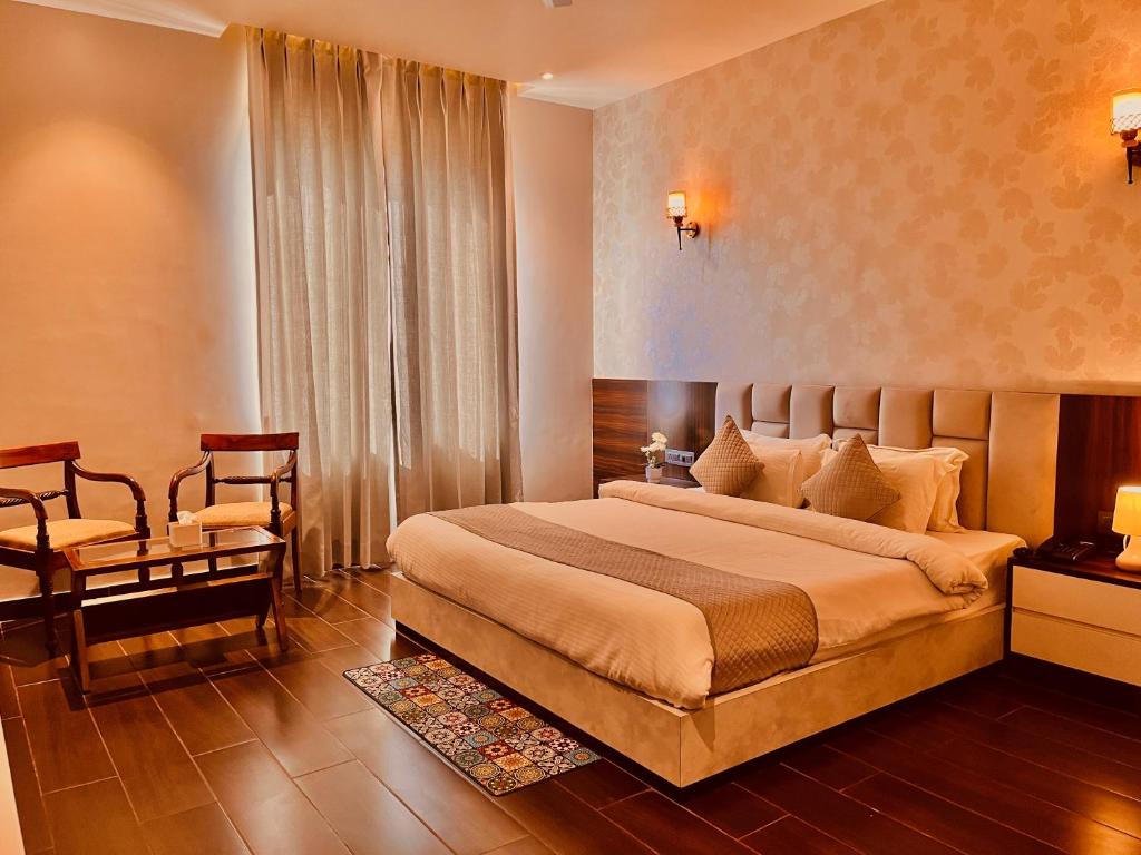 a bedroom with a large bed and a chair at Hotel The Fortune Luxury Rooms Near Mall Road Manali By Vistas - Best Selling Centrally Heated Property 2025-26 in Manāli