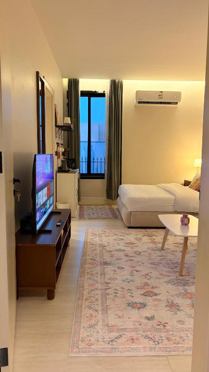 a hotel room with a bed and a flat screen tv at August in Jazan