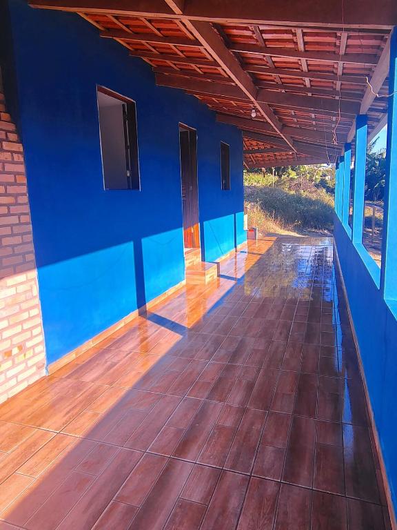 a room with a blue wall and a wooden floor at Vila Azul Casa Completa em Ibicoara in Ibicoara
