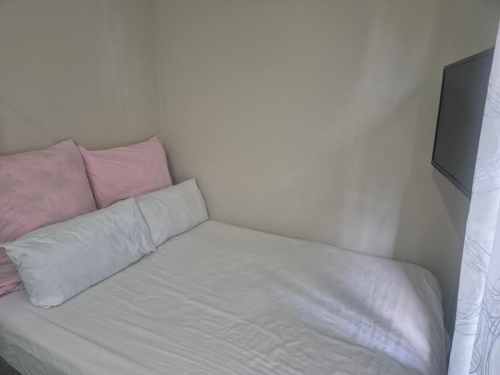 a small room with a bed and a television at Refresh & Recharge 721 in Durban