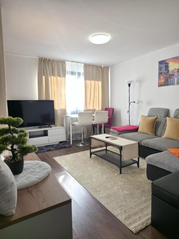 a living room with a couch and a tv at HappyNest in Böblingen