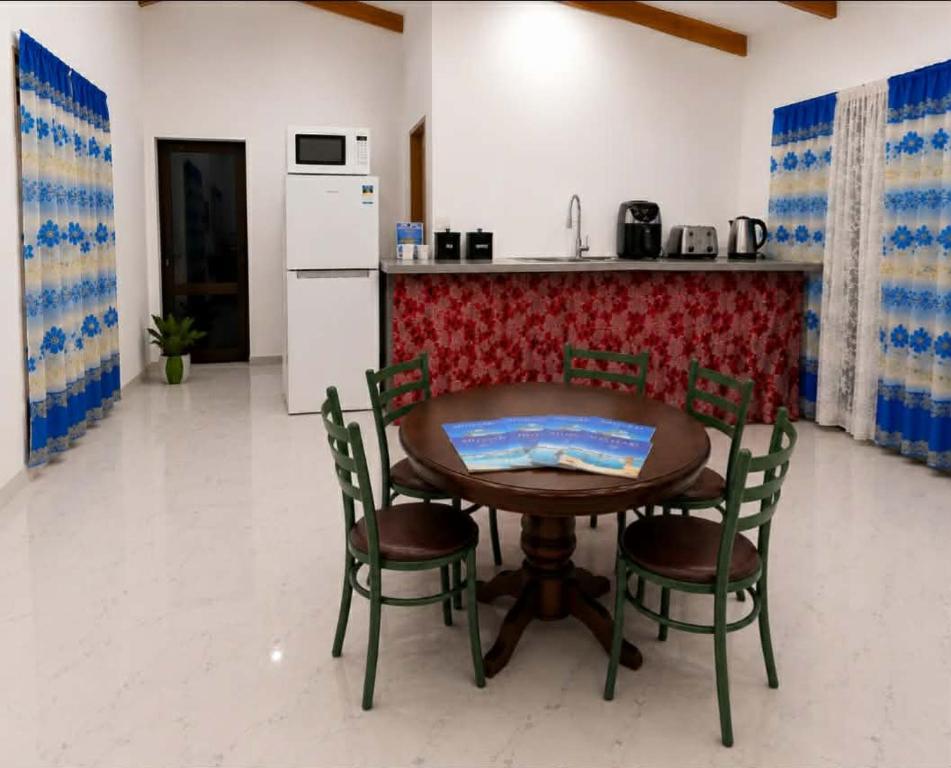 a table and chairs in a kitchen with a counter at Mouare Hideaway in Arutanga