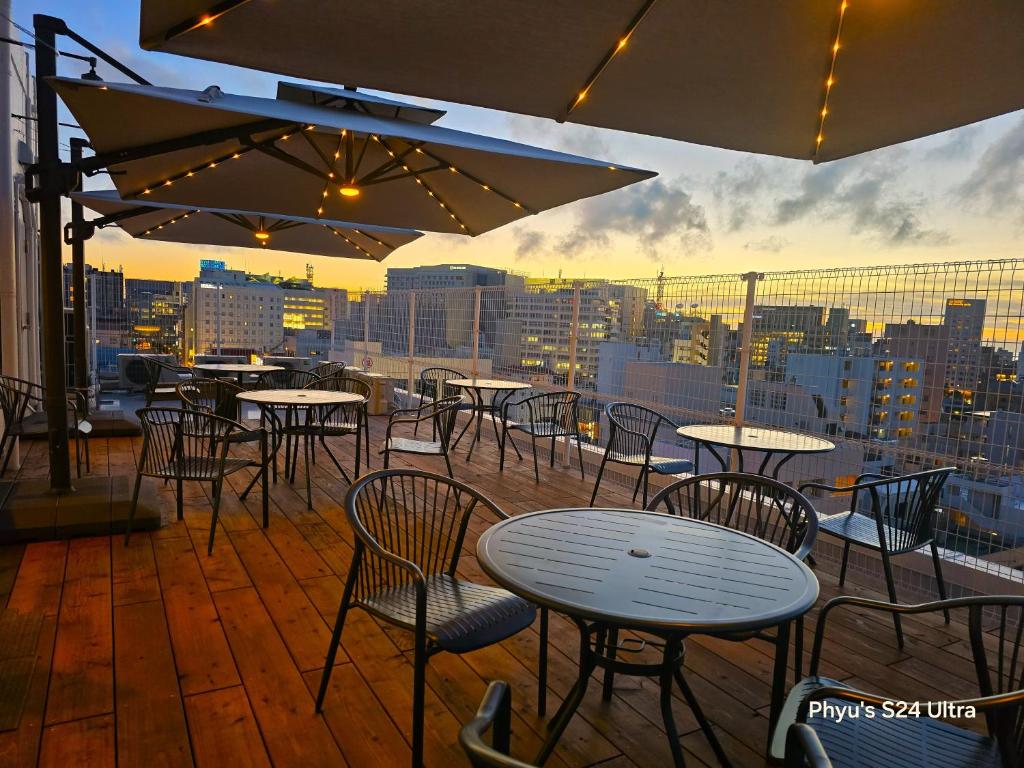 a patio with tables and chairs and a view of a city at Hotel Naha City -Kokusai Street- in Naha