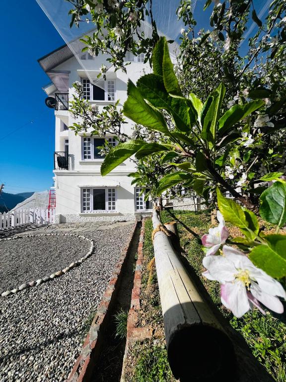 a white house with flowers in front of it at The Sayo Ratnari in Bāgi