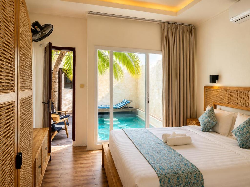 a bedroom with a bed and a swimming pool at Eve Evy Private Pool Villas in Nusa Lembongan