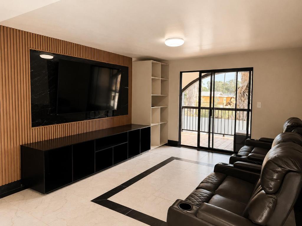 a living room with a couch and a flat screen tv at Sereno Business Inn in Ensenada