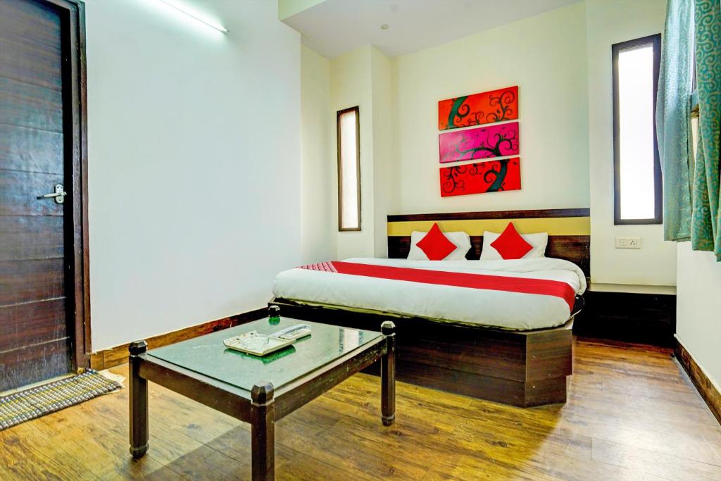 a bedroom with a bed and a table in it at Super Hotel O Sunshin Deluxe in Nagpur