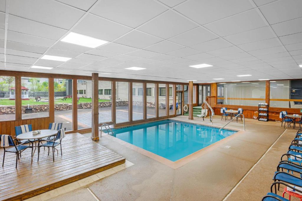 a swimming pool in a building with chairs and a table at Quality Inn & Suites Goshen in Goshen