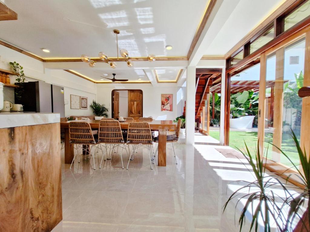 an open kitchen and dining room with a table and chairs at Three-Bedroom Luxury Garden Villa by Sing Siargao in General Luna