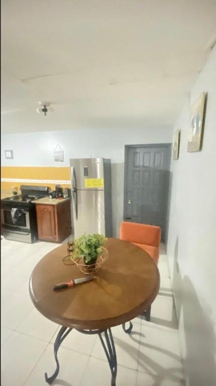 a kitchen with a table and a refrigerator at Villa lux in Portmore