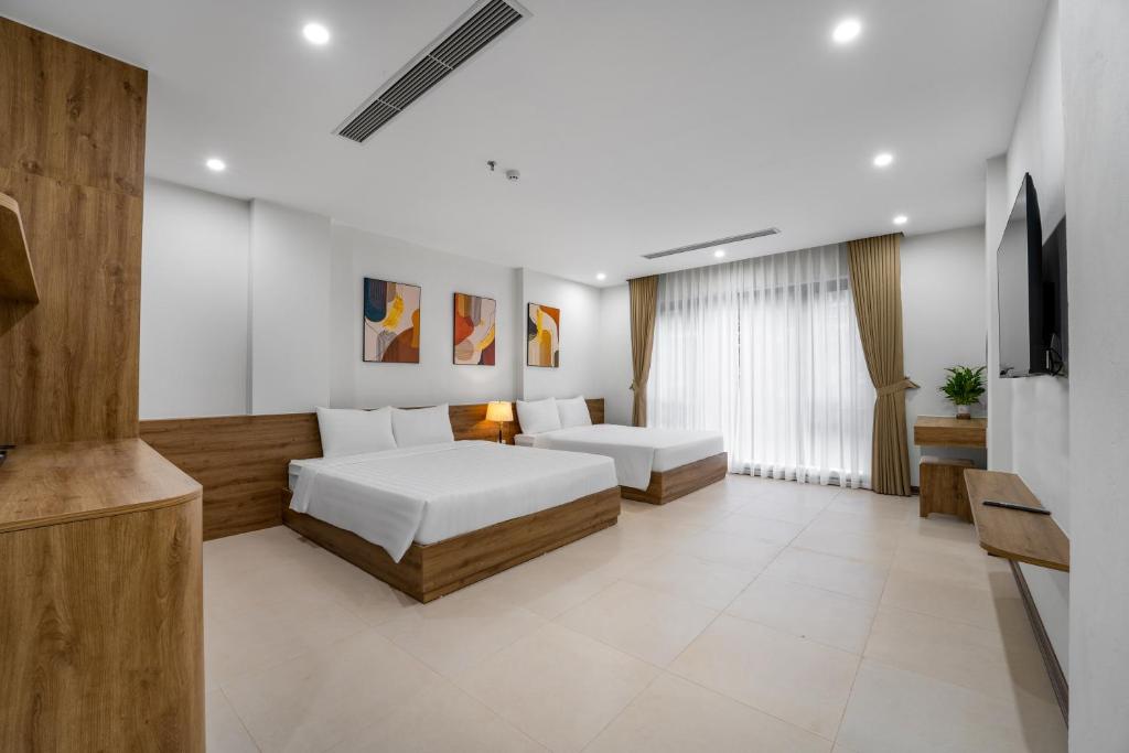 a bedroom with two beds and a flat screen tv at Gao House in Hanoi